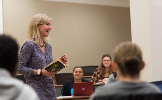 Teacher holds book during lecture 